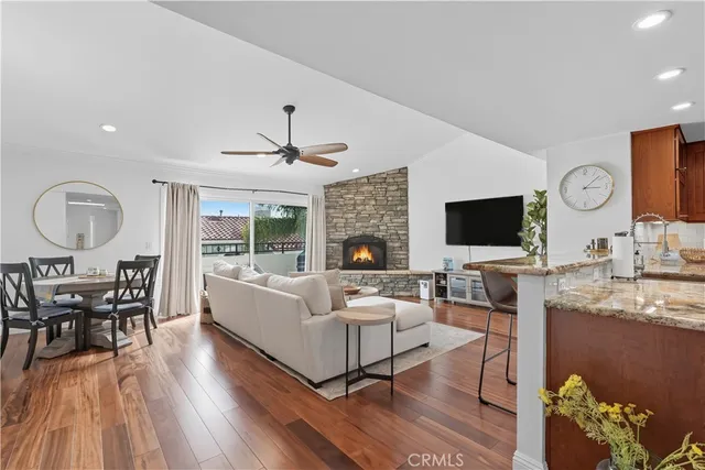 a living room with furniture flat screen tv and wooden floor