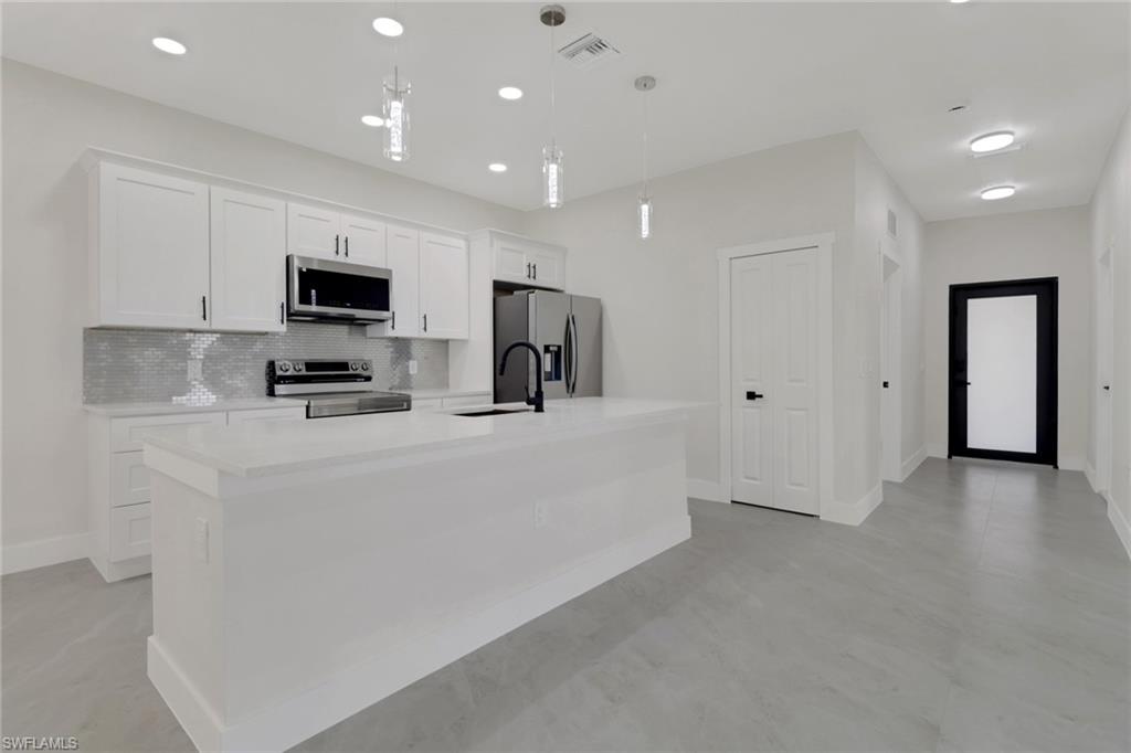 4501-4503 15th Street Southwest Lehigh Acres, FL 33973 - Photo 11 of 50 a view of kitchen with stainless steel appliances cabinets and a refrigerator
