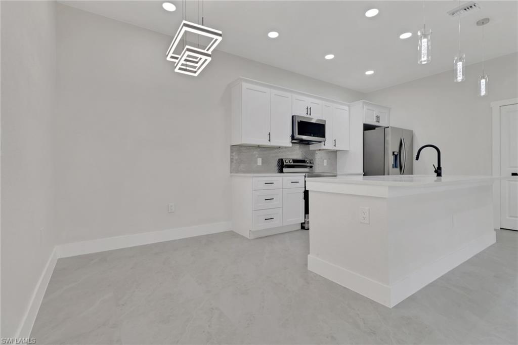 4501-4503 15th Street Southwest Lehigh Acres, FL 33973 - Photo 15 of 50 a view of cabinets a sink a stove and a window