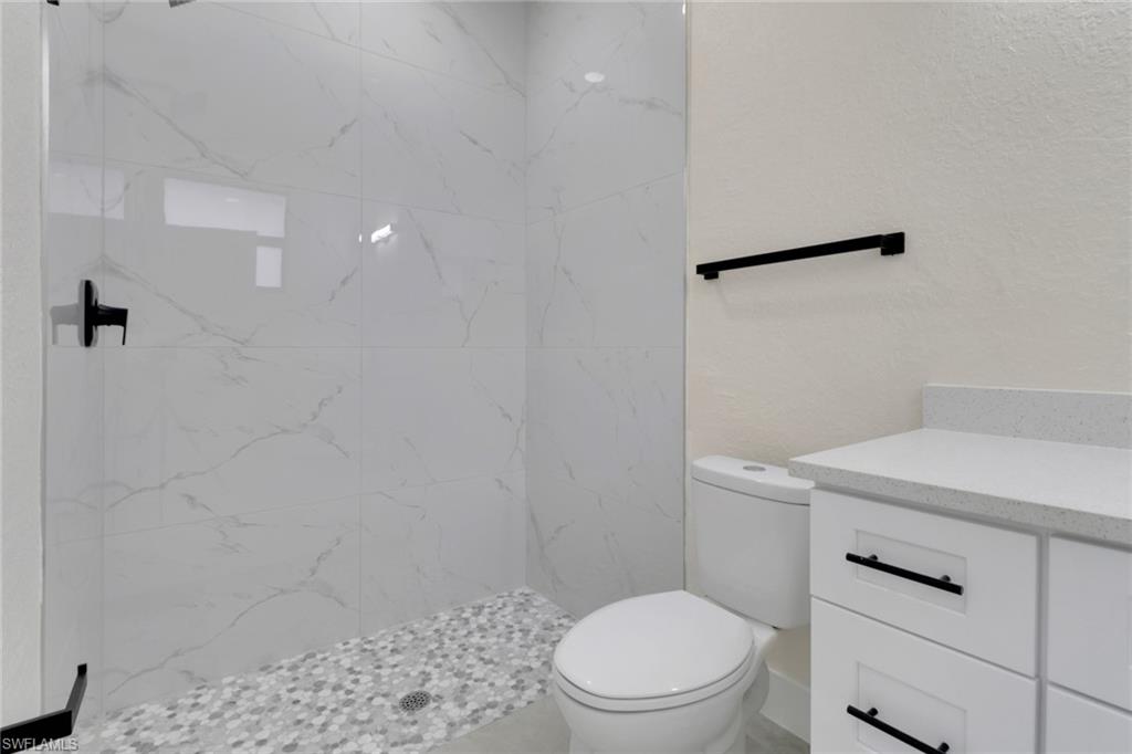 4501-4503 15th Street Southwest Lehigh Acres, FL 33973 - Photo 19 of 50 a white toilet sitting next to a shower