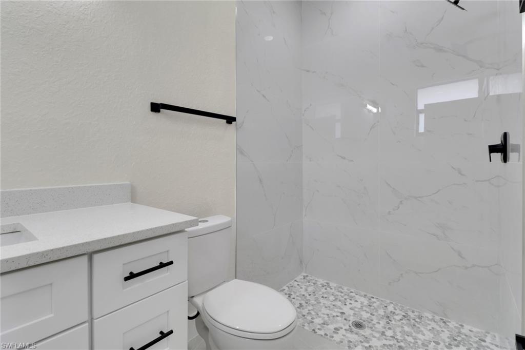 4501-4503 15th Street Southwest Lehigh Acres, FL 33973 - Photo 30 of 50 a bathroom with a sink a toilet and vanity