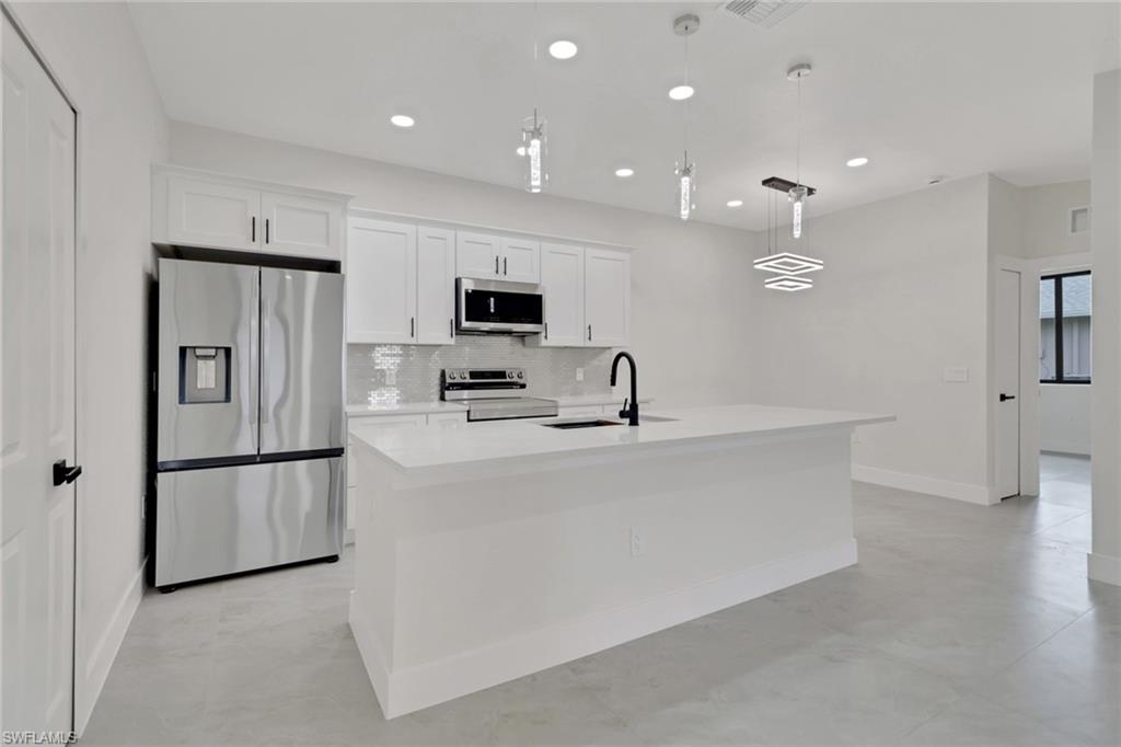 4501-4503 15th Street Southwest Lehigh Acres, FL 33973 - Photo 7 of 50 a view of kitchen with stainless steel appliances kitchen island sink and refrigerator