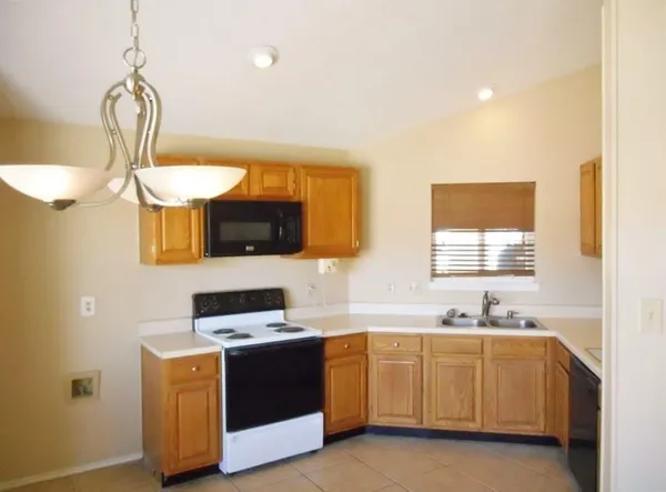 a kitchen with a sink and a stove top oven with wooden floor