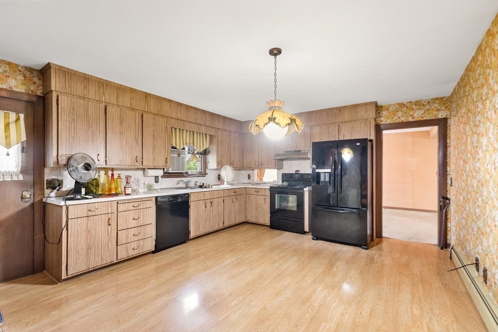 4 R Forest Street Peabody, MA 01960 - Photo 8 of 33 a kitchen with a refrigerator a sink dishwasher with a fireplace and wooden floor