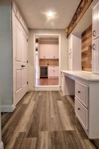 an empty room with wooden floor chandelier fan and windows