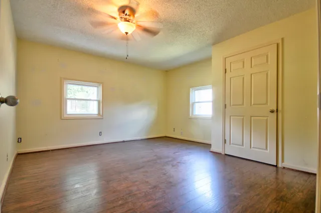 a view of a room with a window and wooden floor