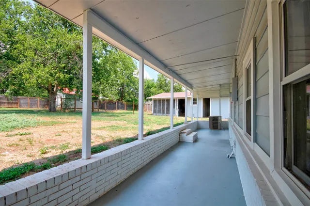 a view of a backyard with table and chairs under an umbrella