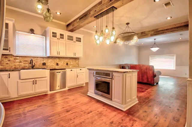 a kitchen with a sink cabinets and wooden floor