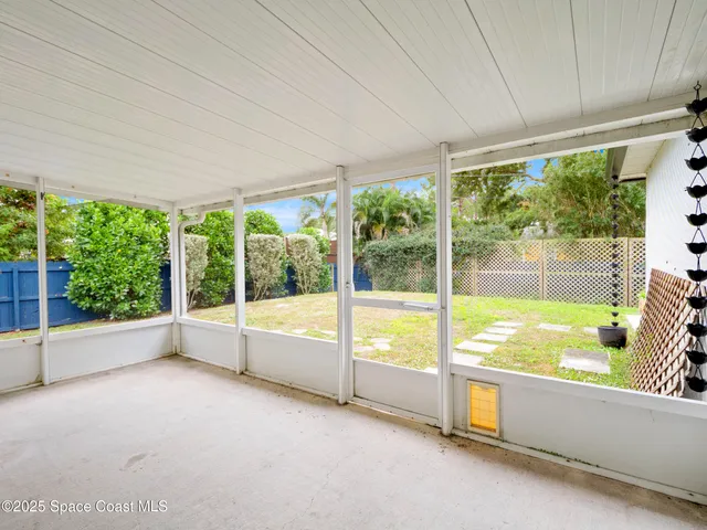 a view of an empty room with a large window with pool view