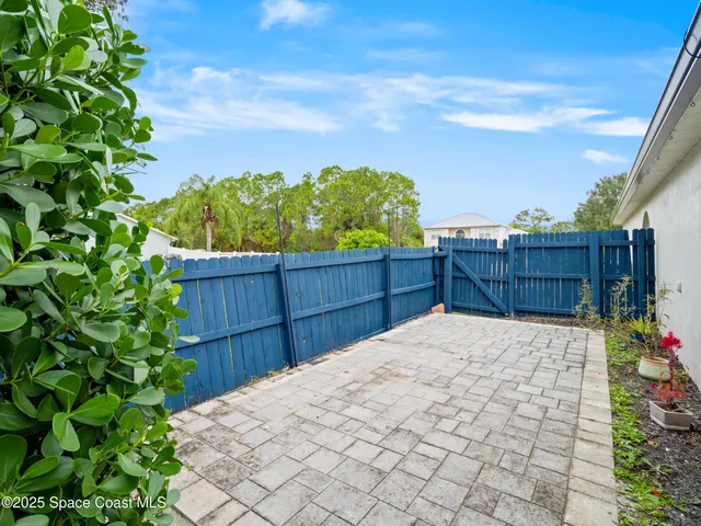 a view of backyard with wooden fence