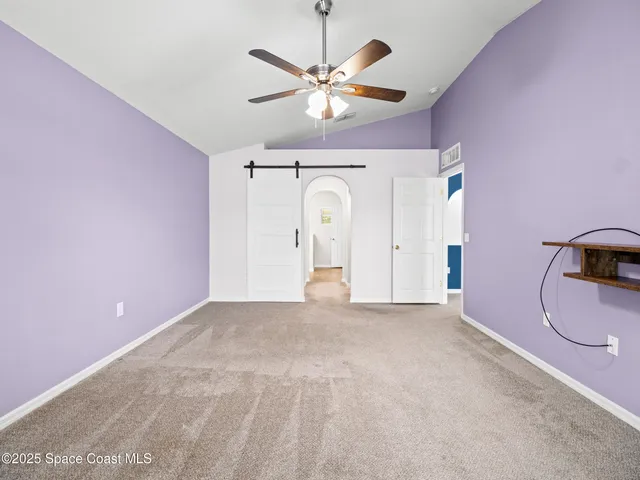 a view of a livingroom with a ceiling fan and entryway