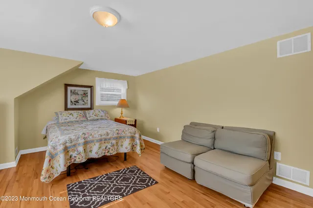 a bedroom with a bed couch and a night stand