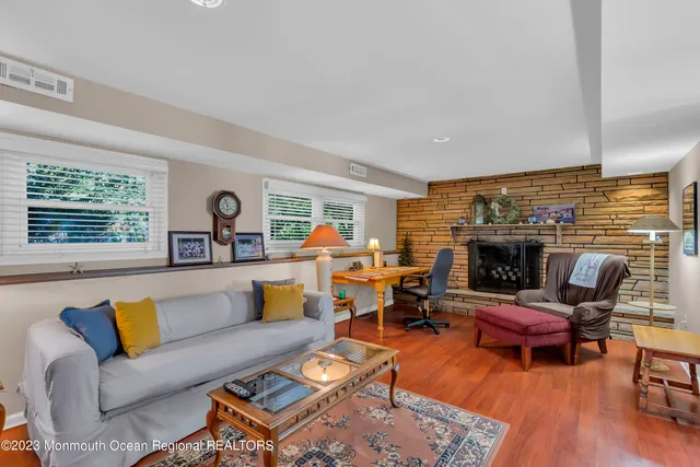 a living room with furniture fireplace and a large window
