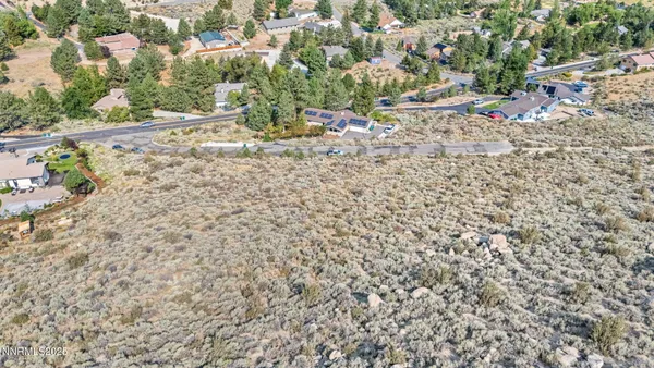 a view of a dry yard with wooden fence