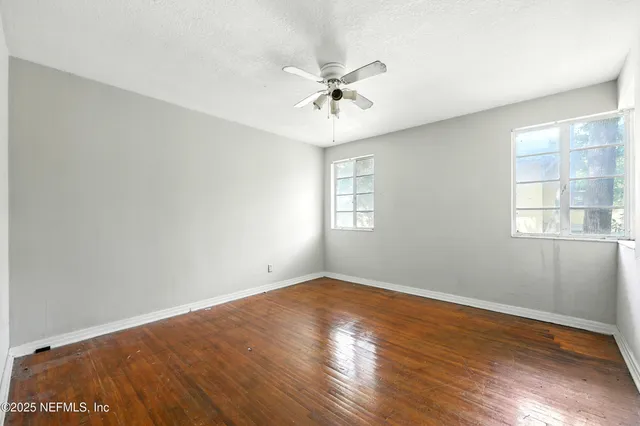 an empty room with closet and windows