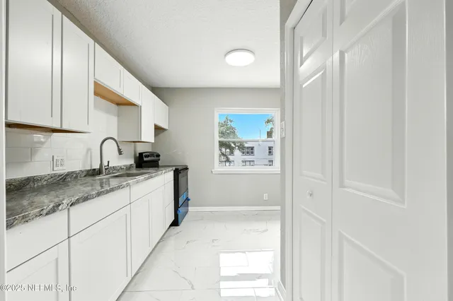 an aerial view of residential house with outdoor space and trees all around