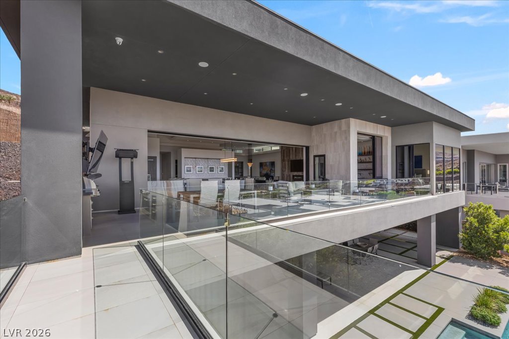 657 Ridgestone Rim Court Henderson, NV 89012 - Photo 53 of 97 Sleek glass railings border a covered terrace overlooking the manicured lower level.