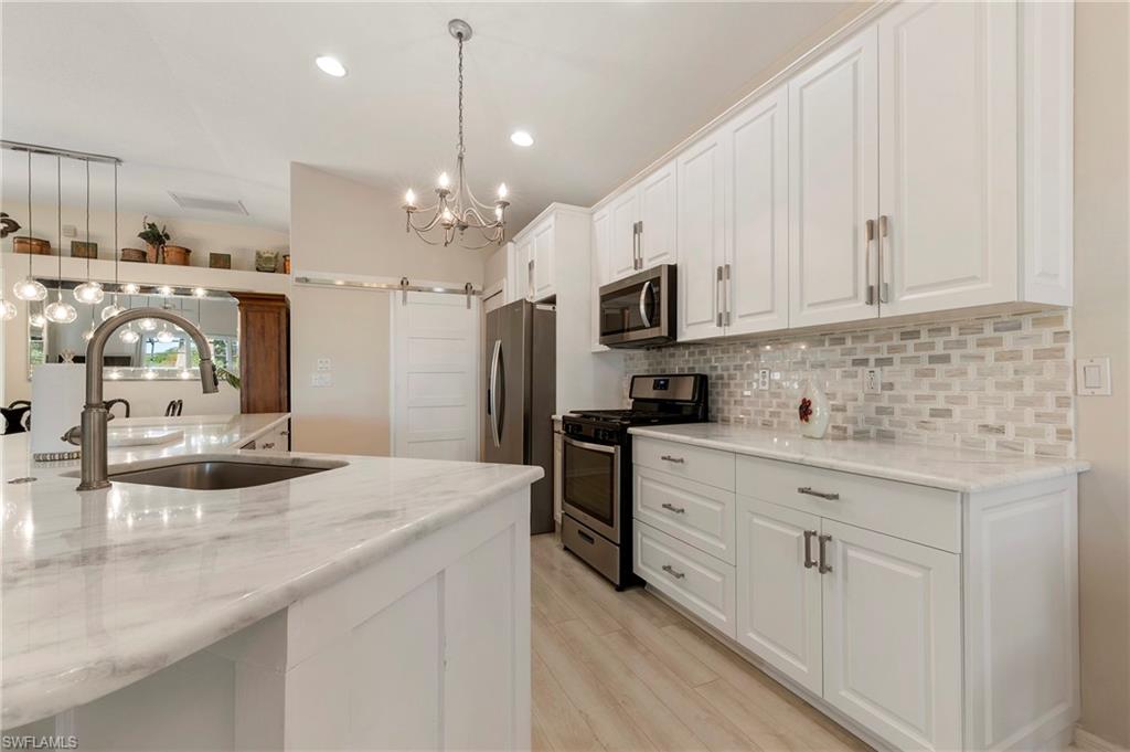 17819 Modena Road Fort Myers, FL 33913 - Photo 11 of 50 a kitchen with kitchen island granite countertop a sink appliances cabinets and a counter top space