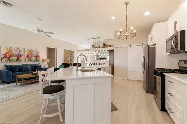 a kitchen that has a lot of cabinets a sink and a stove in it