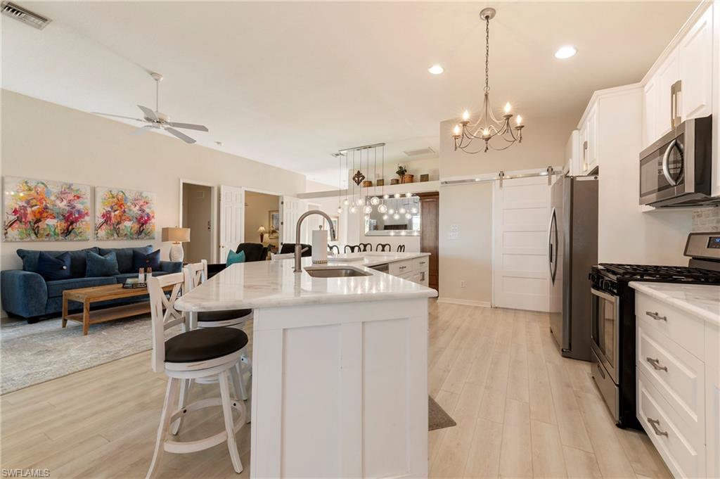 17819 Modena Road Fort Myers, FL 33913 - Photo 12 of 50 a kitchen that has a lot of cabinets a sink and a stove in it