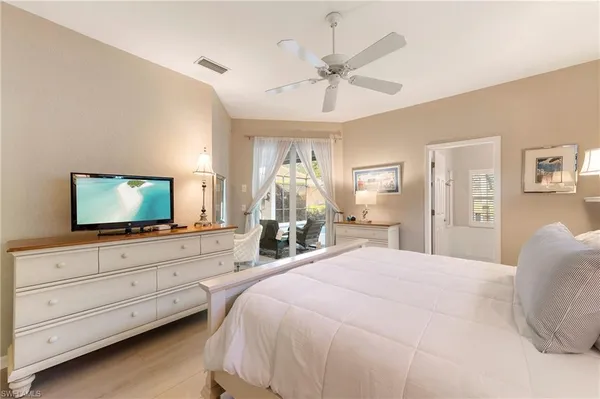 a bedroom with a bed and a flat tv screen on dresser