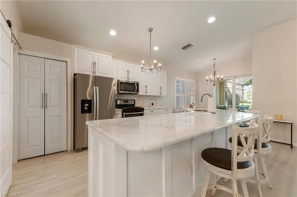a kitchen with refrigerator and chairs