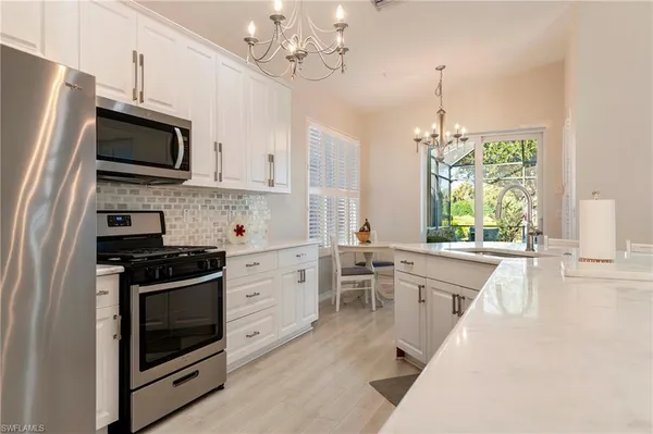 a kitchen with stainless steel appliances a stove sink microwave and cabinets