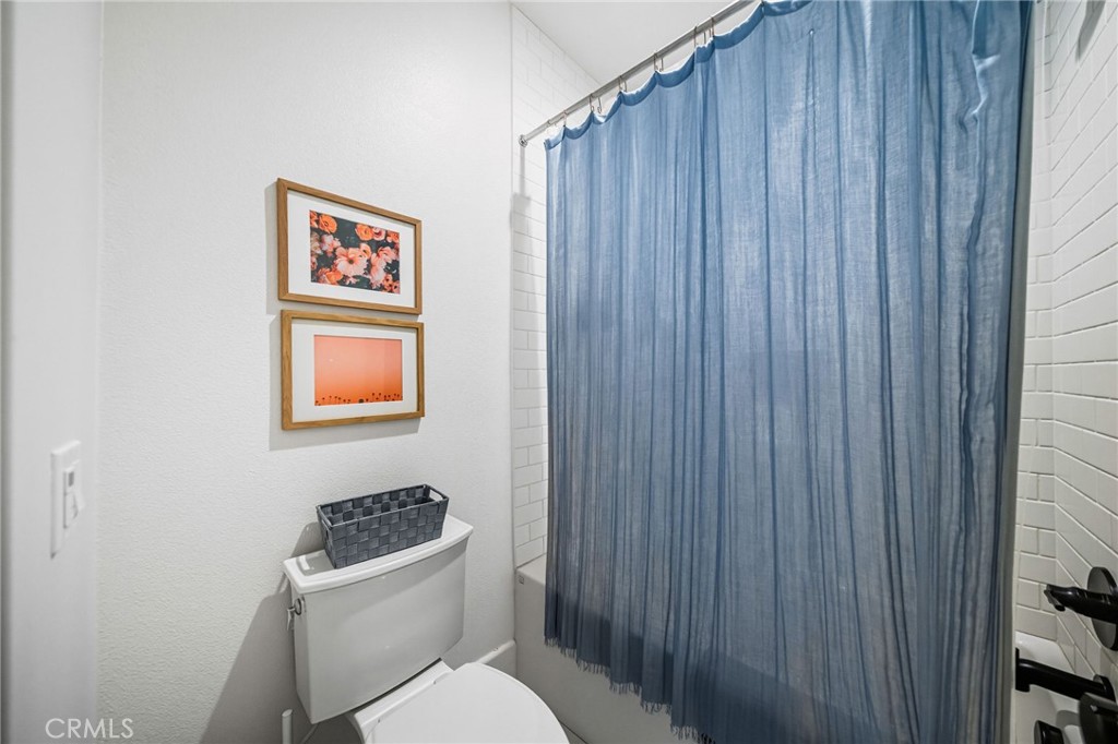 32017 Radiant Drive Temecula, CA 92591 - Photo 45 of 74 a bathroom with a toilet a sink and a shower curtain