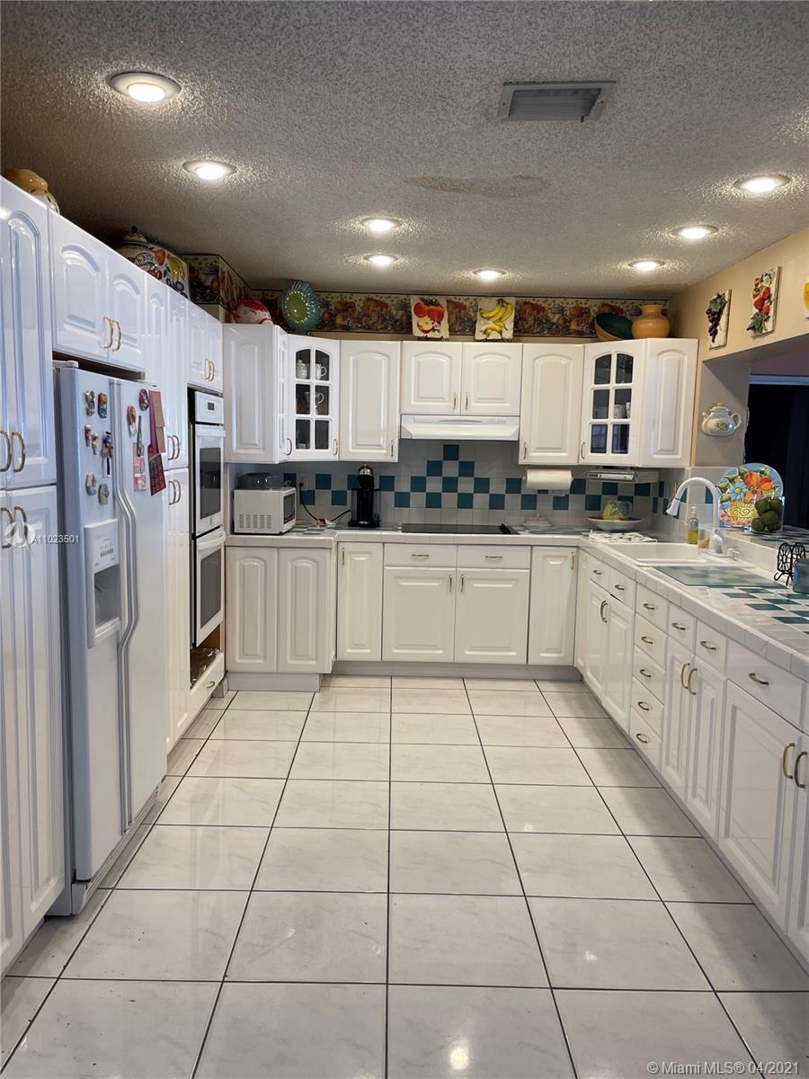 a kitchen with stainless steel appliances a sink a stove a microwave and a refrigerator