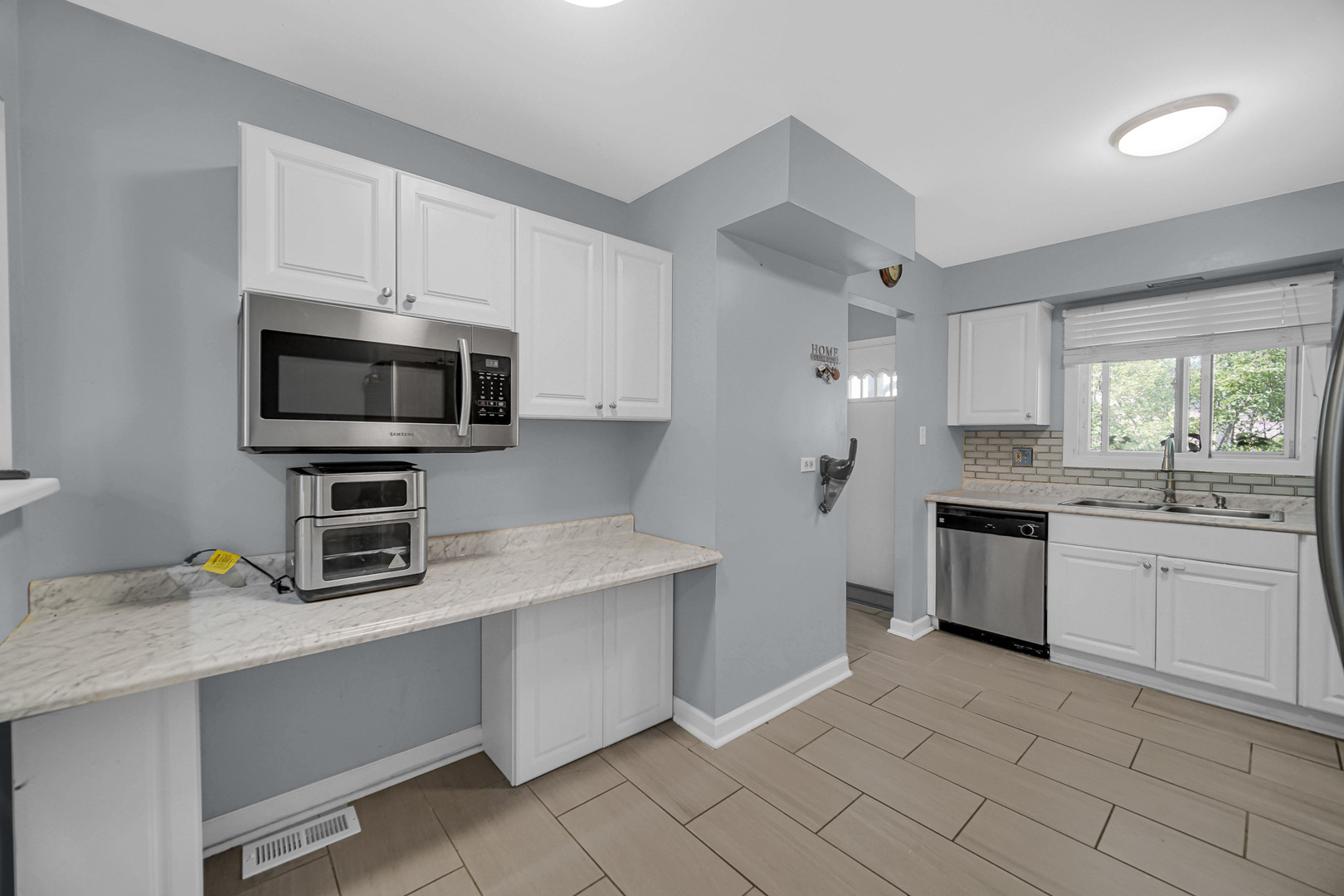 1010 Heathrow Court Wheaton, IL 60189 - Photo 11 of 24 a kitchen with granite countertop a sink stainless steel appliances and white cabinets