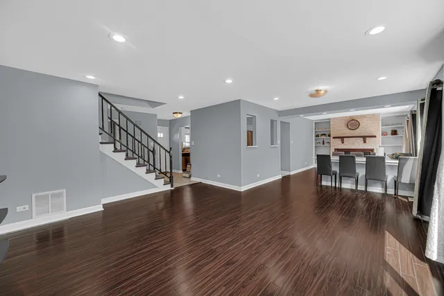 a view of a livingroom with wooden floor and stairs