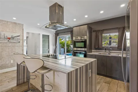 a kitchen with stainless steel appliances granite countertop a sink a stove and a refrigerator