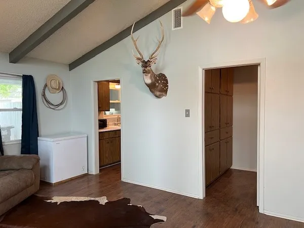 a kitchen with stainless steel appliances granite countertop a refrigerator a sink dishwasher a dining table and chairs with wooden floor