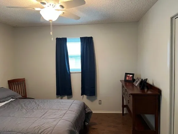 a view of an empty room with wooden floor and closet