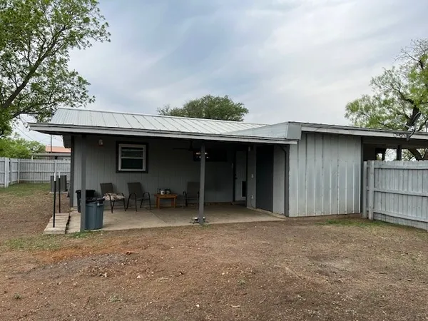 a view of backyard with wooden fence