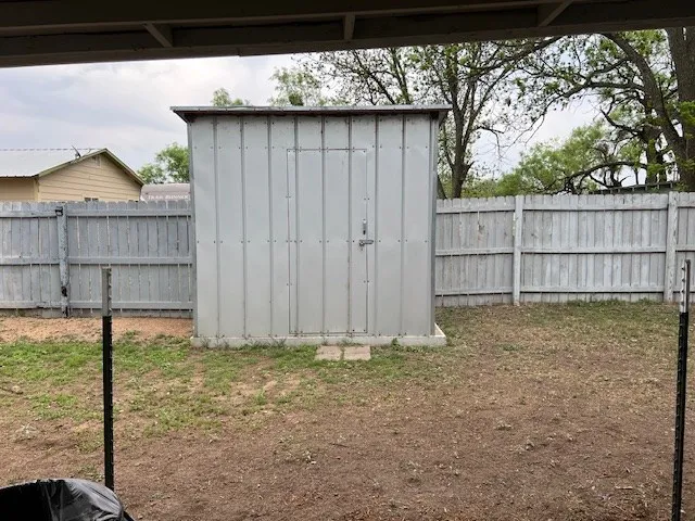 a view of a house with a yard and large tree