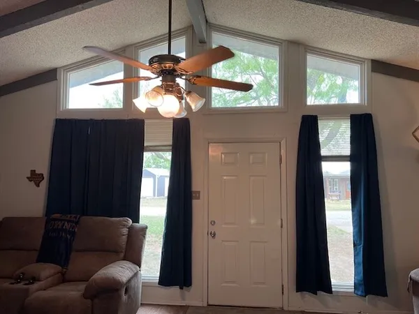 a living room with furniture a ceiling fan and a window