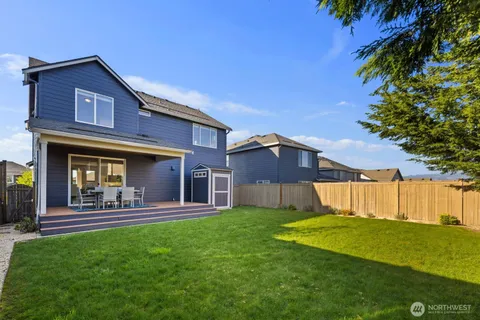 a view of a house with a yard porch and wooden fence