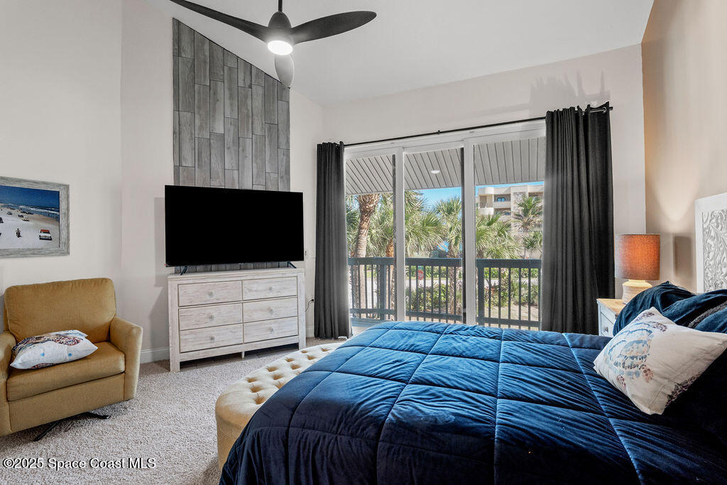 3044 South Hwy A1A, Unit 3C Melbourne Beach, FL 32951 - Photo 13 of 30 a bedroom with a bed couch and a flat tv screen