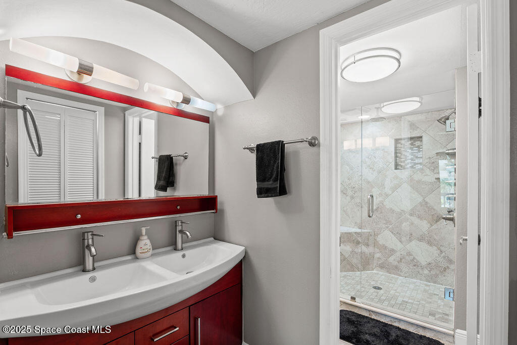 3044 South Hwy A1A, Unit 3C Melbourne Beach, FL 32951 - Photo 15 of 30 a bathroom with a sink vanity granite shower and a mirror