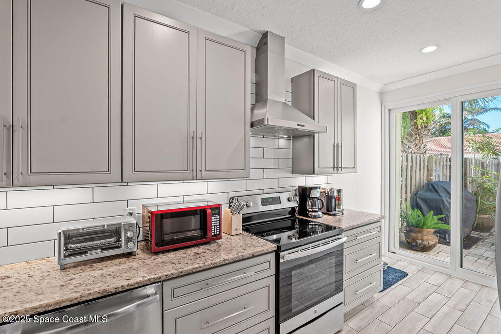 3044 South Hwy A1A, Unit 3C Melbourne Beach, FL 32951 - Photo 10 of 30 a kitchen with stainless steel appliances granite countertop a stove a sink and a microwave