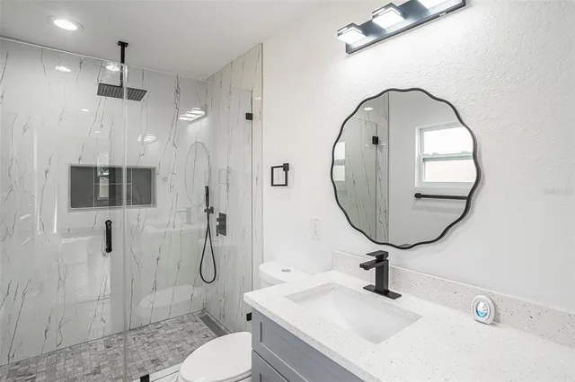 a bathroom with a sink a toilet and a mirror