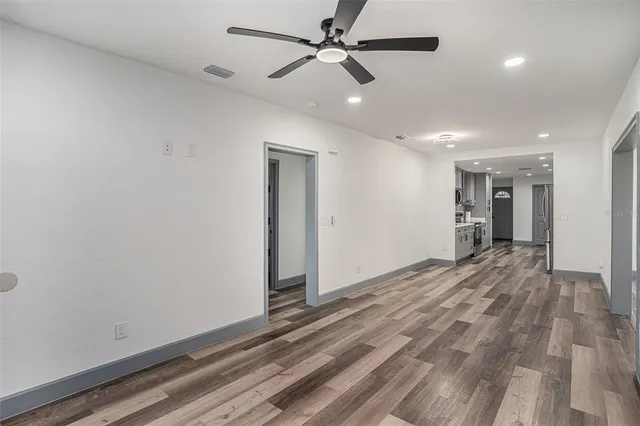 a view of empty room with wooden floor