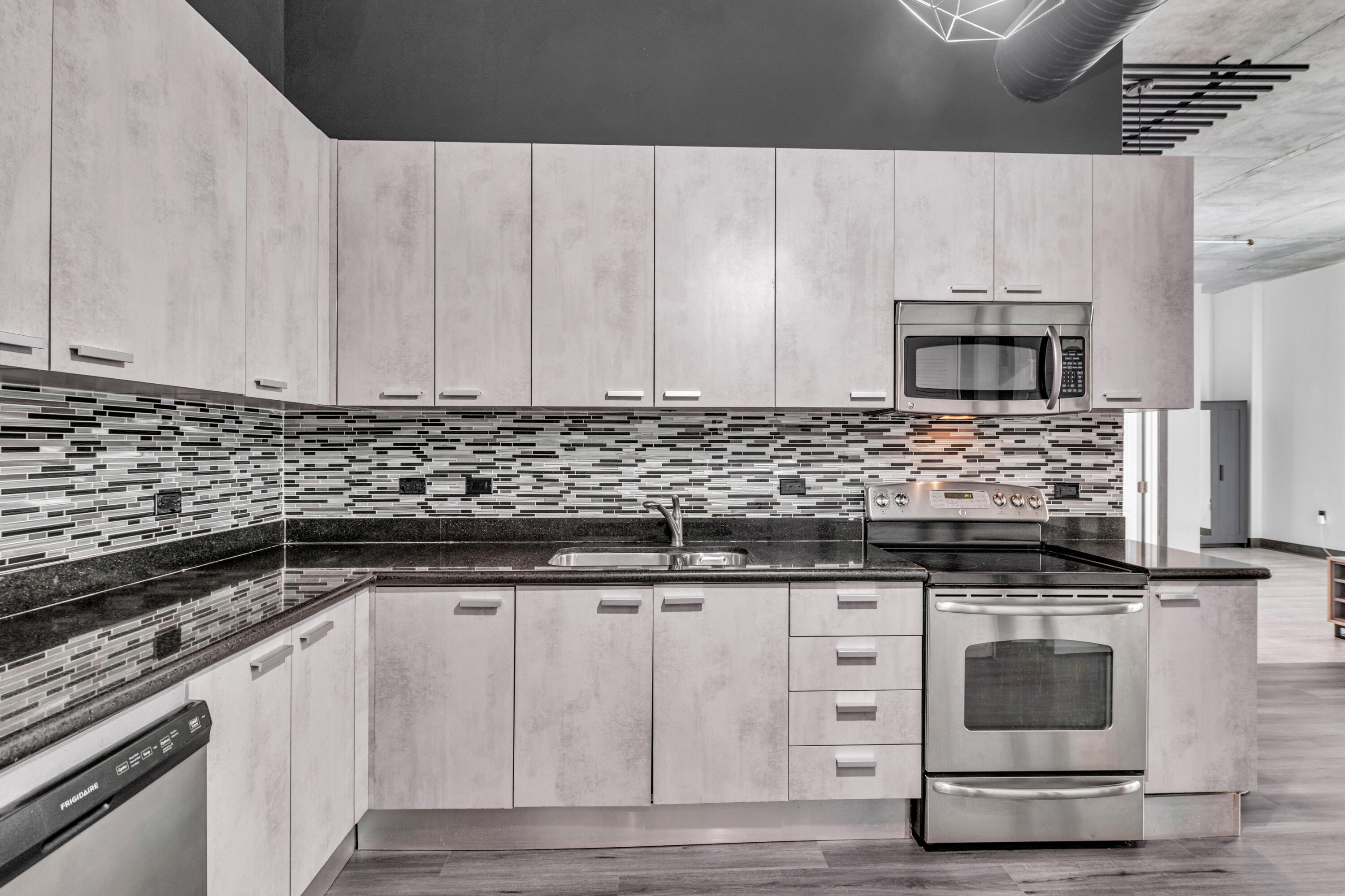 2100 Van Buren Street, Unit 203 Hollywood, FL 33020 - Photo 11 of 28 a kitchen with granite countertop a stove and white cabinets
