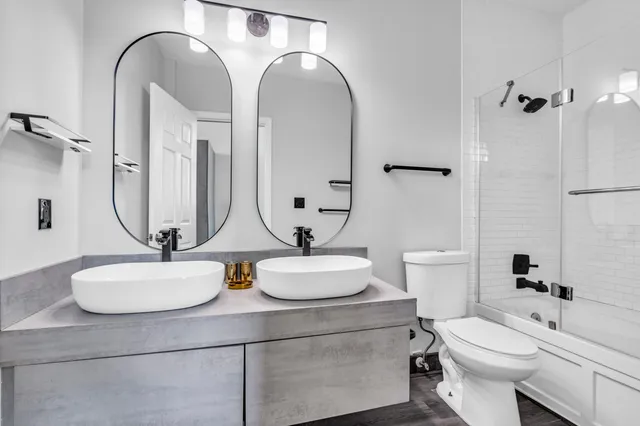 a bathroom with a double vanity sink toilet and a mirror