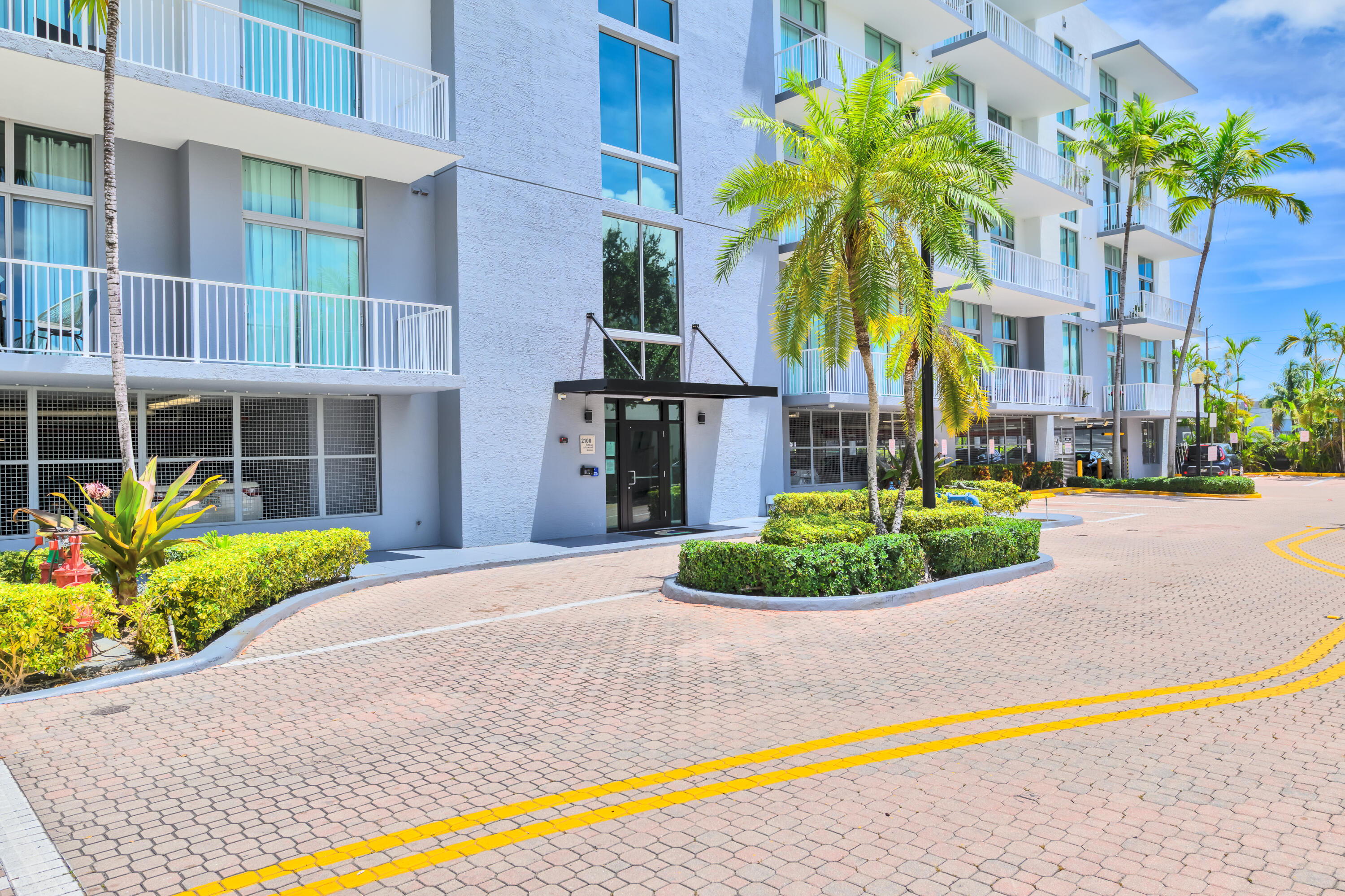 2100 Van Buren Street, Unit 203 Hollywood, FL 33020 - Photo 25 of 28 a front view of a house with a yard and potted plants