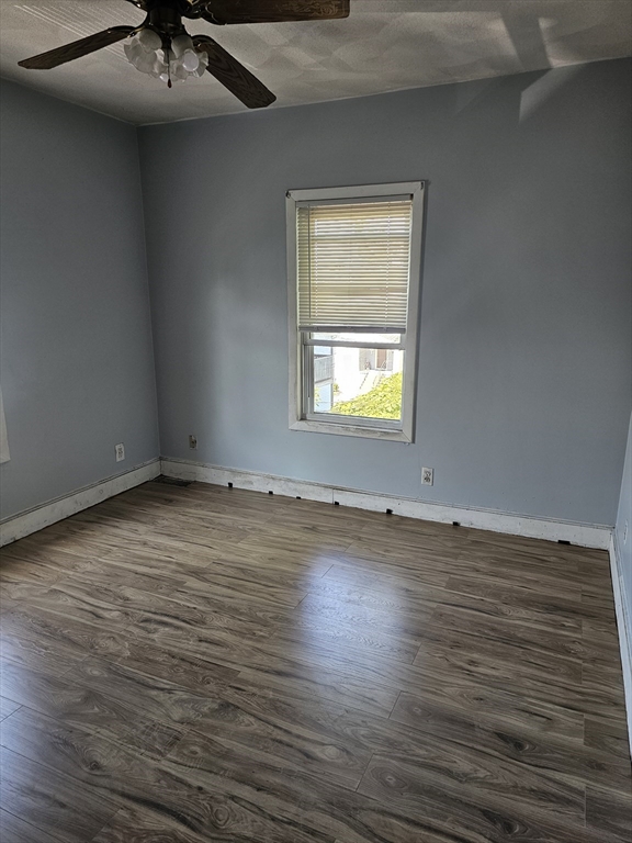 233-235 Main Street Everett, MA 02149 - Photo 19 of 20 an empty room with a chandelier fan and wooden floor