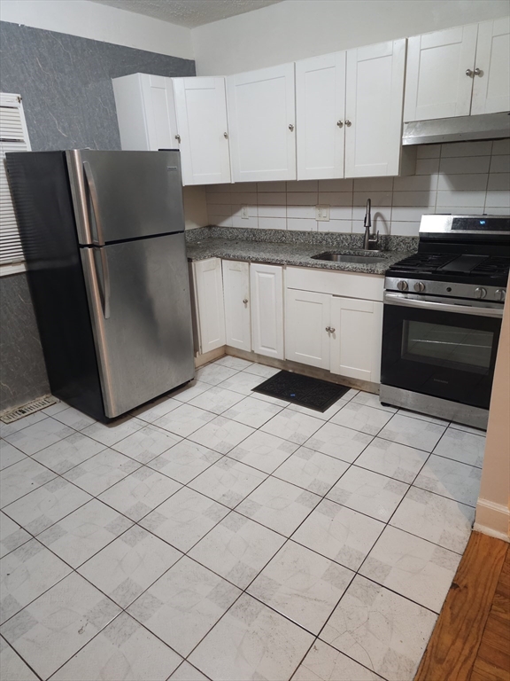 233-235 Main Street Everett, MA 02149 - Photo 2 of 20 a kitchen with a sink a stove a refrigerator and cabinets