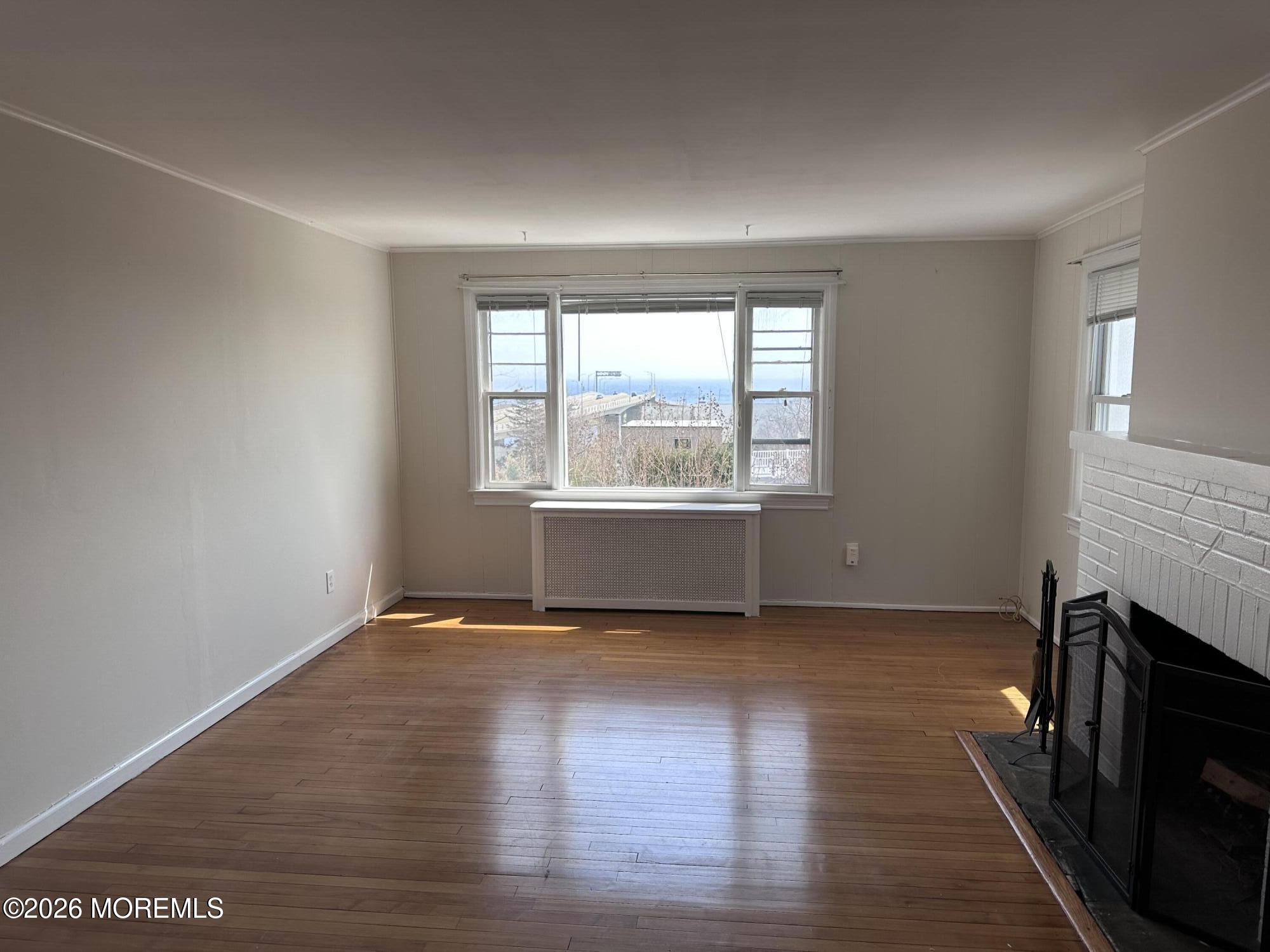 10 Ocean Street Highlands, NJ 07732 - Photo 3 of 15 an empty room with wooden floor and windows