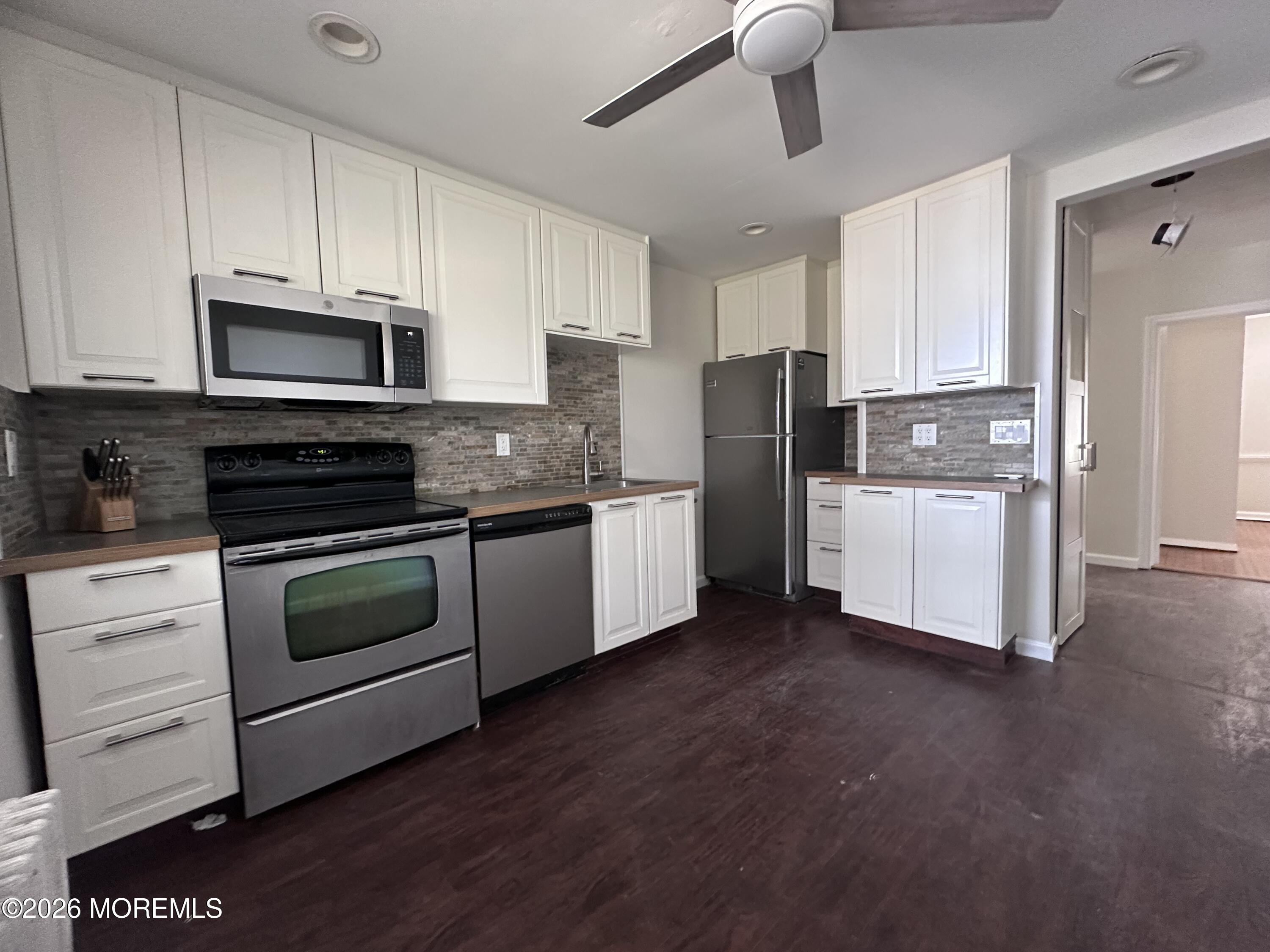 10 Ocean Street Highlands, NJ 07732 - Photo 5 of 15 a kitchen with stainless steel appliances white cabinets and a refrigerator
